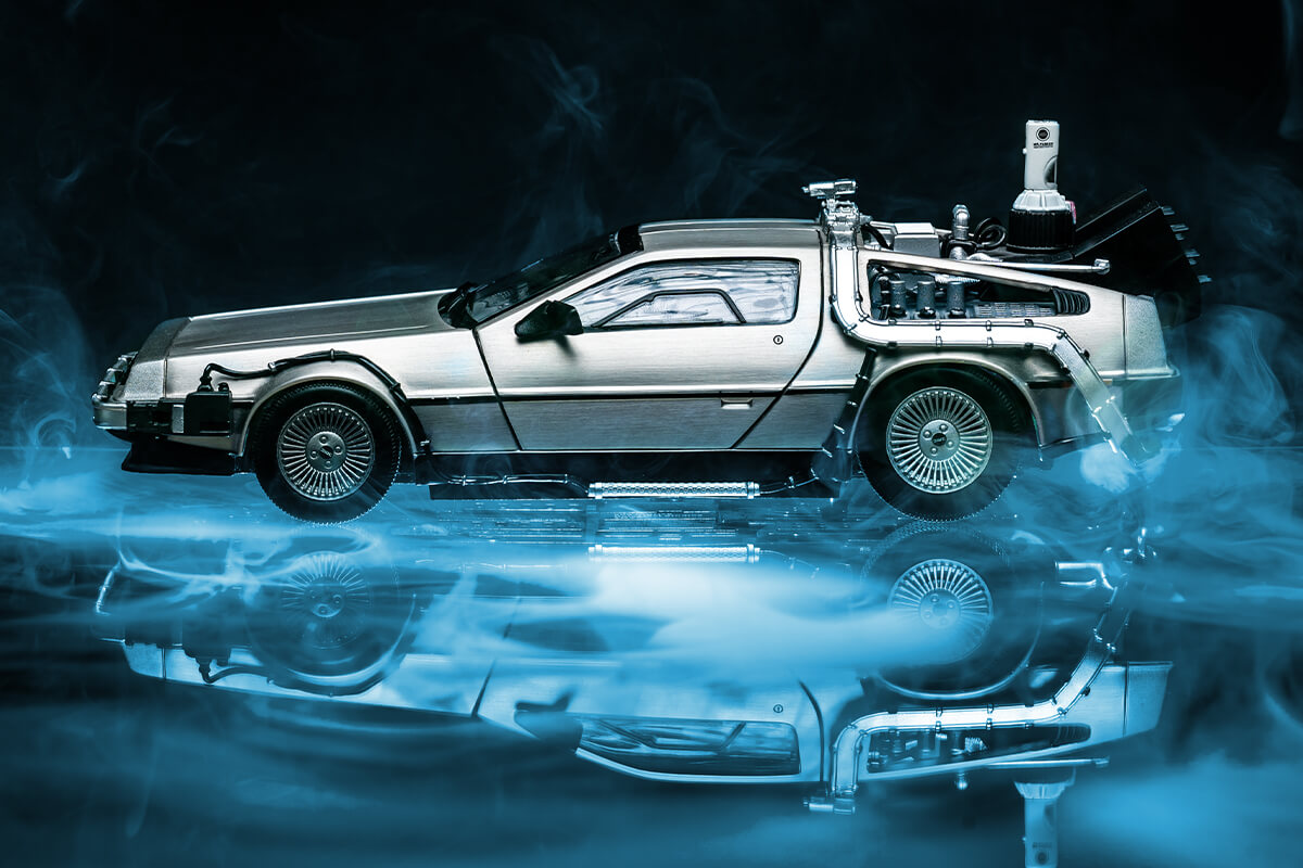 Modellauto des DeLorean aus Zurück in die Zukunft, schwebend über einer spiegelnden Fläche im blauen Nebel