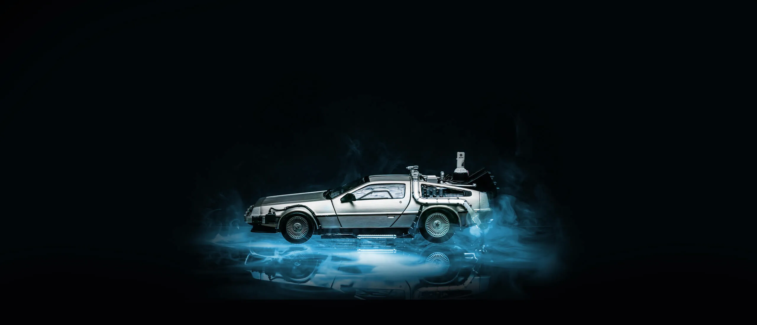 Der DeLorean aus „Zurück in die Zukunft" in blauem Licht vor schwarzem Hintergrund