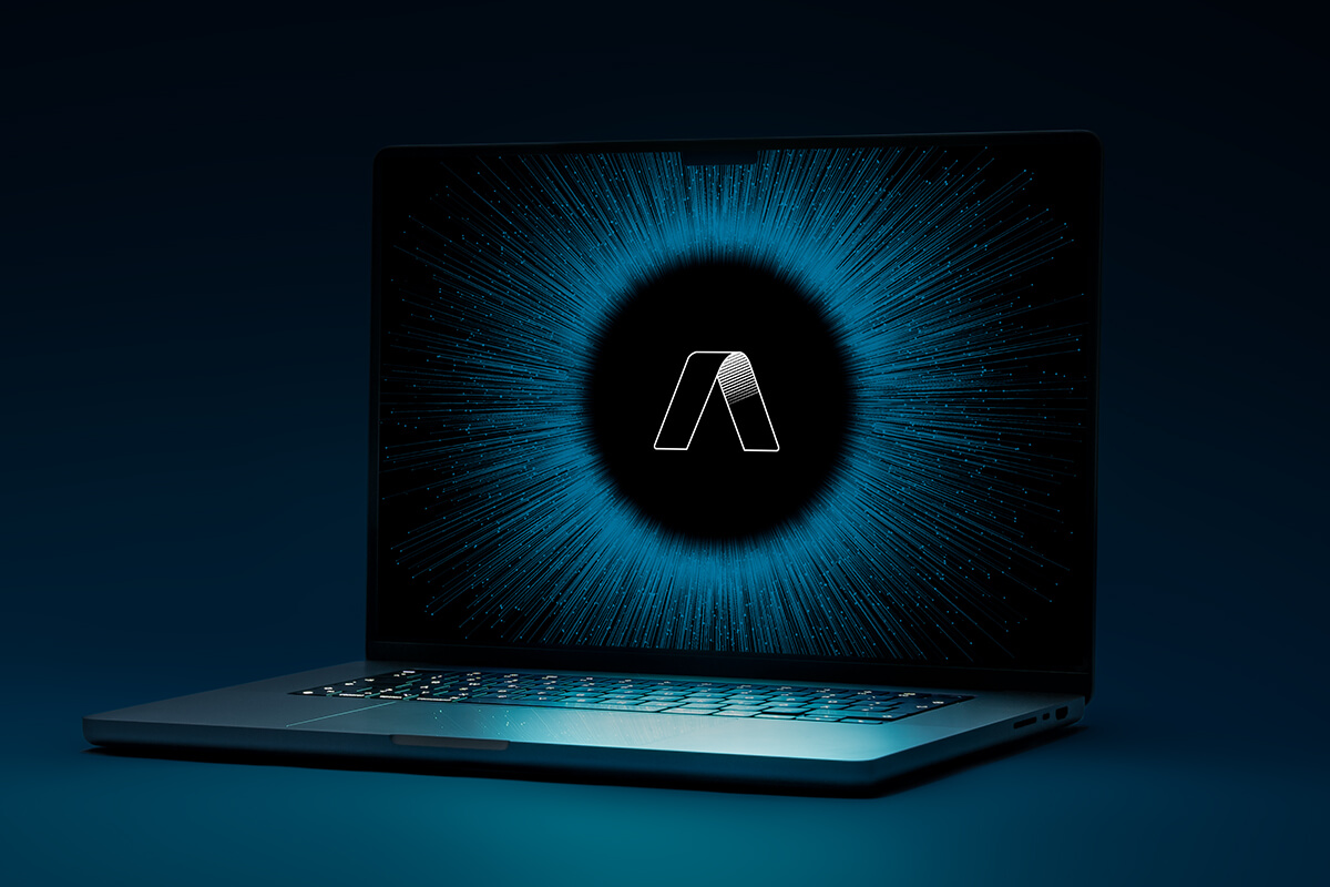 Aufgeklappter Laptop im dunklen Raum, auf dem Bildschirm leuchtet das Logo der ad hoc Gruppe