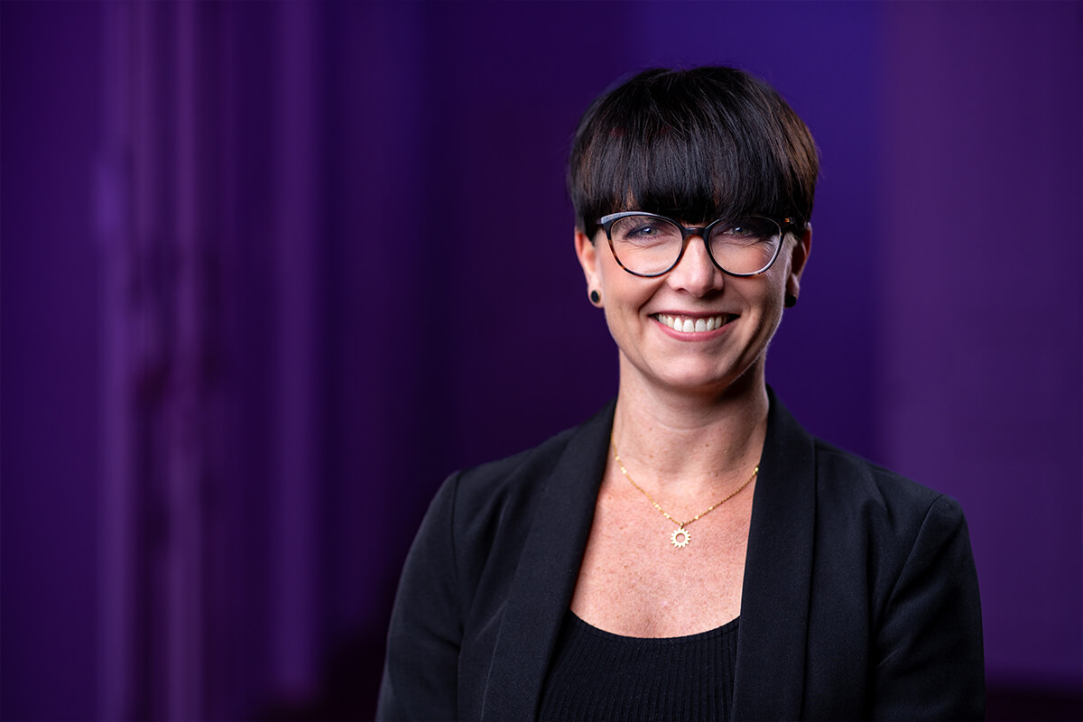 Headshot vor violett ausgeleuchtetem Hintergrund