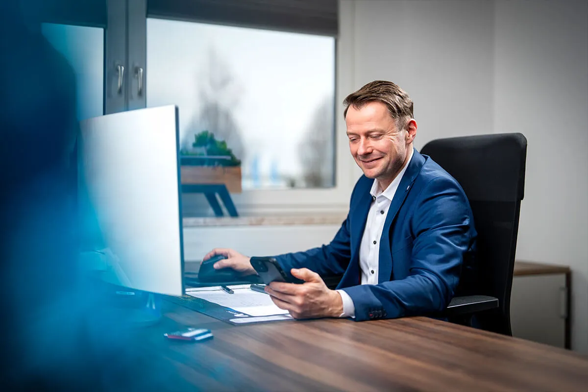 Mitarbeiter am Schreibtisch mit Monitor im Büro der ad hoc Gruppe