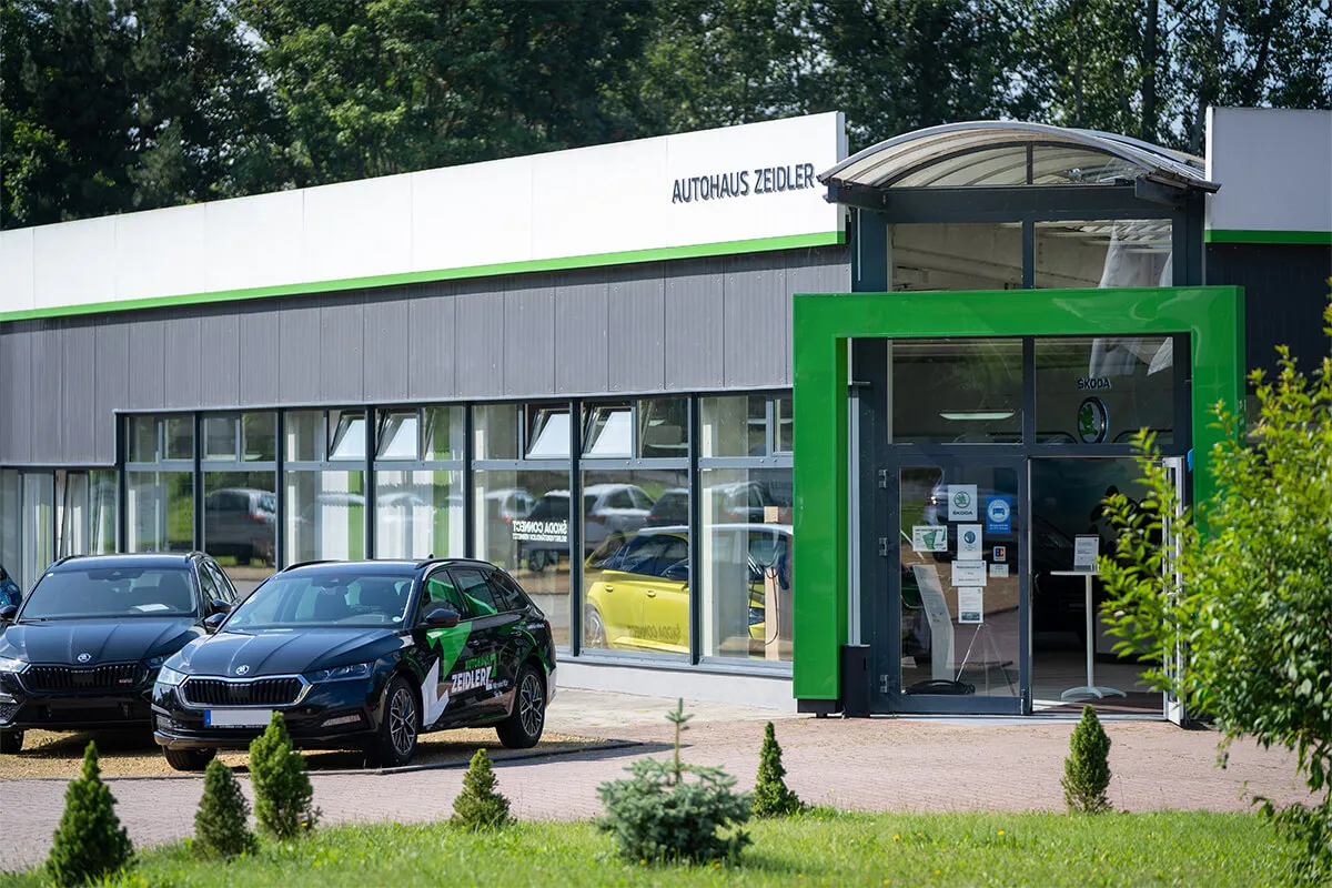 Eingangsbereich des Autohaus Zeidler mit grün akzentuierter Fassade
