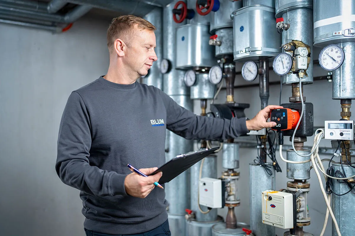 Mitarbeiter prüft die Haustechnik im Heizungsraum