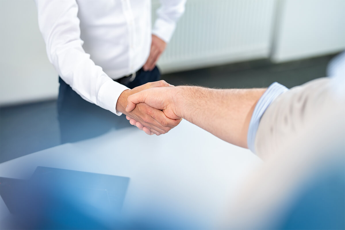 Handschlag über den Besprechungstisch am Ende des Gesprächs