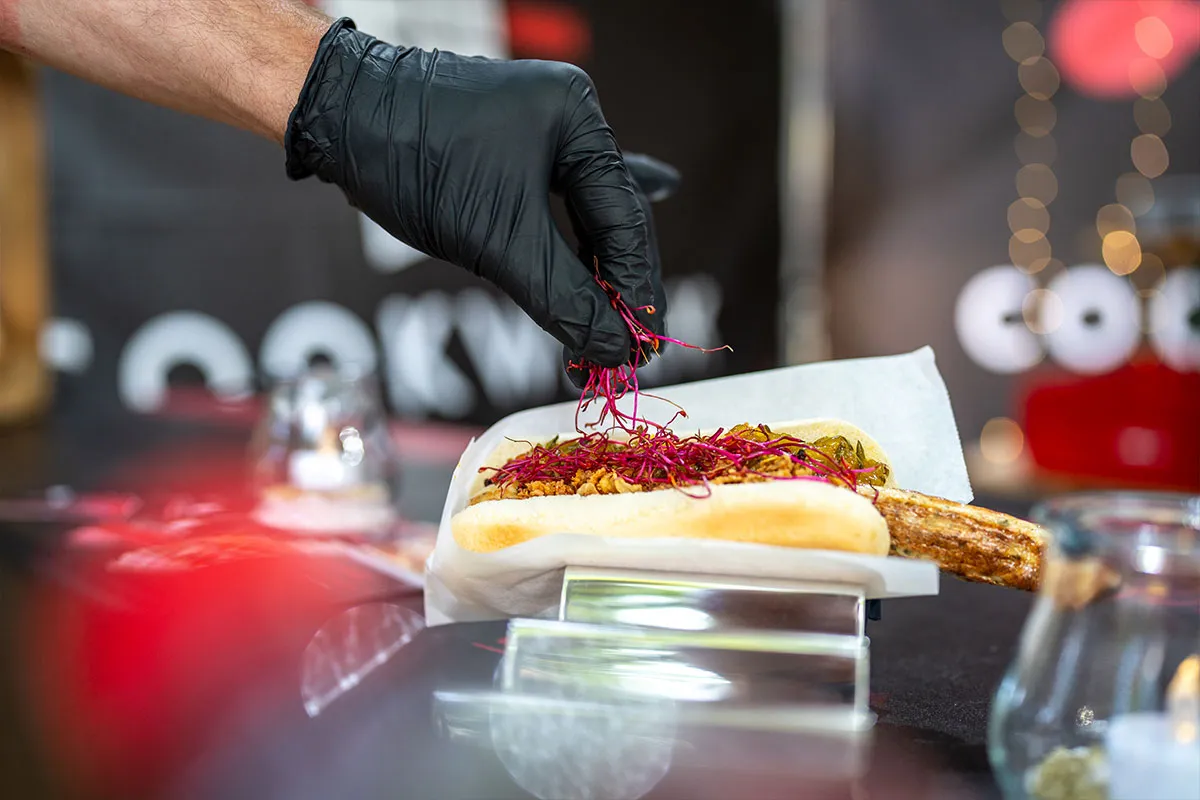 Koch garniert ein Gericht mit Kräutern beim Catering-Einsatz