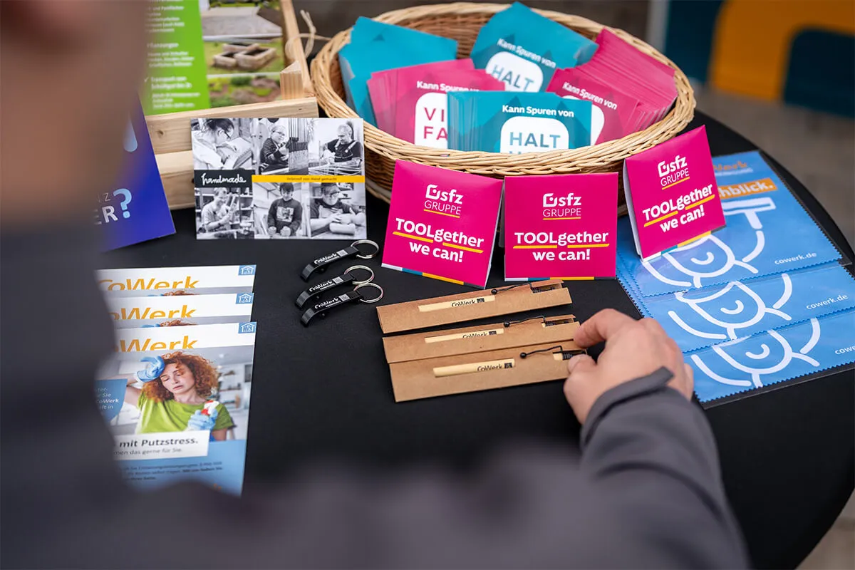 Giveaways und Flyer der SFZ-Gruppe auf einem Tisch beim Fabrikfestival