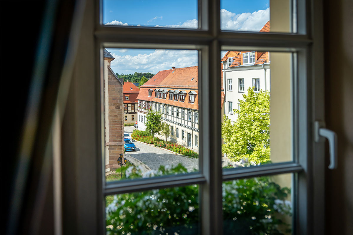 Blick aus dem Zimmerfenster auf Fachwerkhäuser und den Platz davor