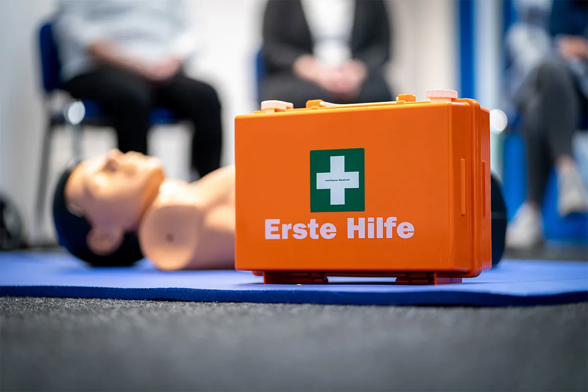 Erste-Hilfe-Koffer vor einer Reanimationspuppe im Schulungsraum