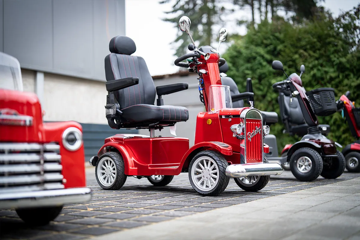 Reihe roter Elektromobile vor dem Firmengebäude