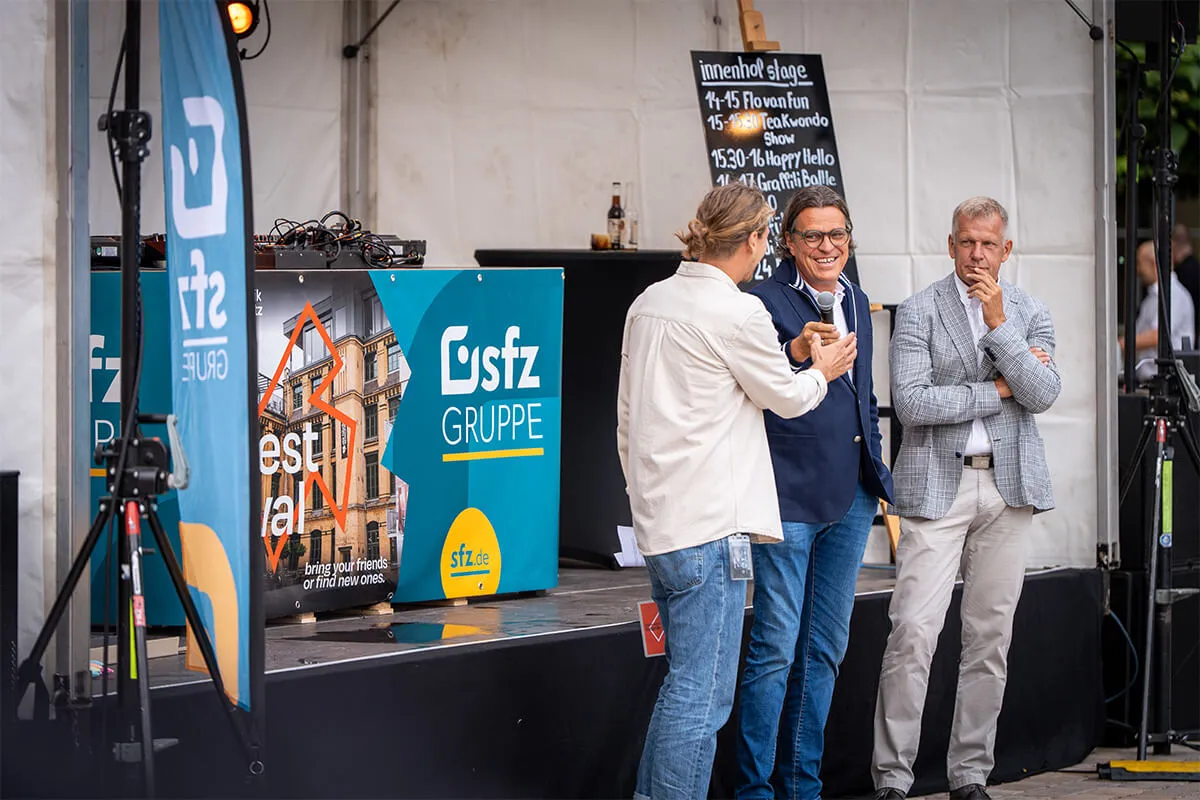 Gesprächsrunde auf der Bühne vor den Bannern der SFZ-Gruppe