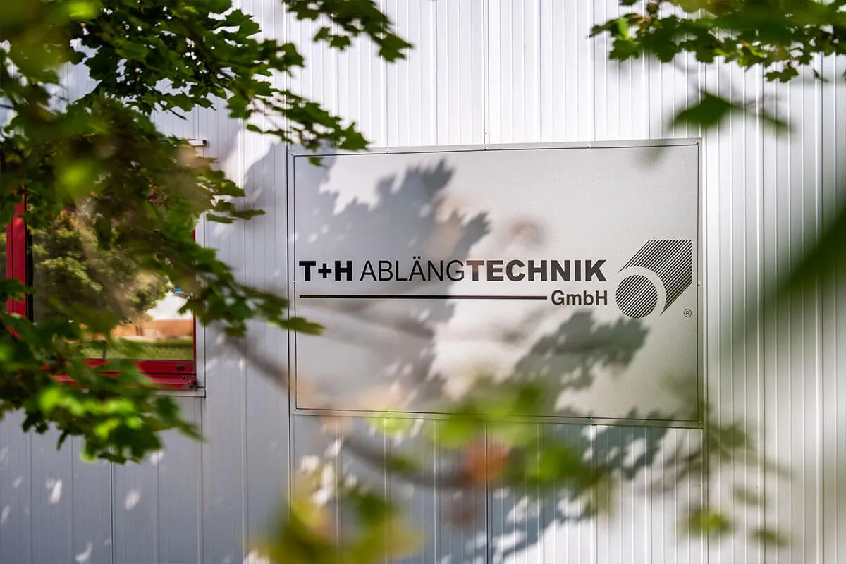 Firmenschild der T+H Ablängtechnik GmbH an der Fassade